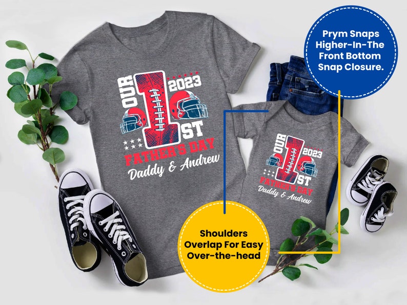 May include: A gray short-sleeved t-shirt with a red and blue football design and the text "Our 1st Father's Day 2023 Daddy & Andrew". A gray short-sleeved bodysuit with the same design and text. The shirts are laid out on a white surface with a pair of black sneakers and green plants.