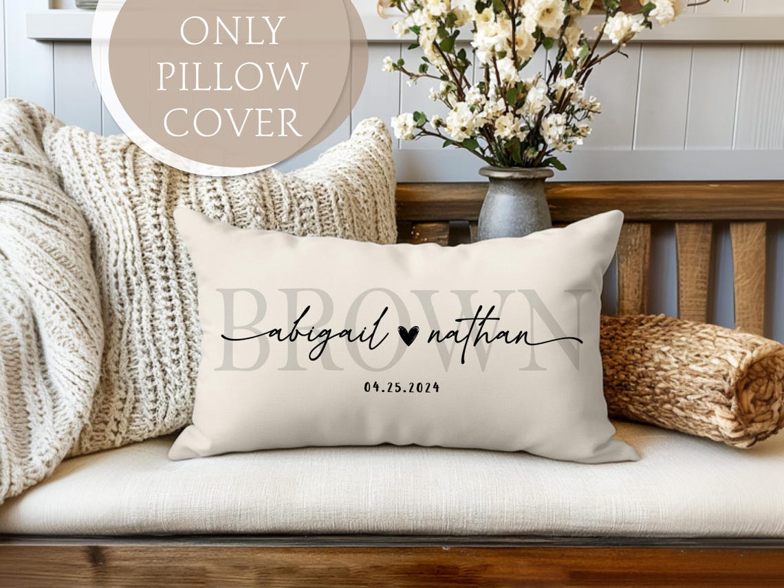 Personalized wedding or anniversary pillow cover featuring custom names, a heart symbol, a special date, and a subtle last name in the background. Made from high-quality fabric, perfect for home decor, engagement gifts, or newlywed presents. Pillow cover only, insert not included. Elegant and timeless design for a cozy, romantic touch.