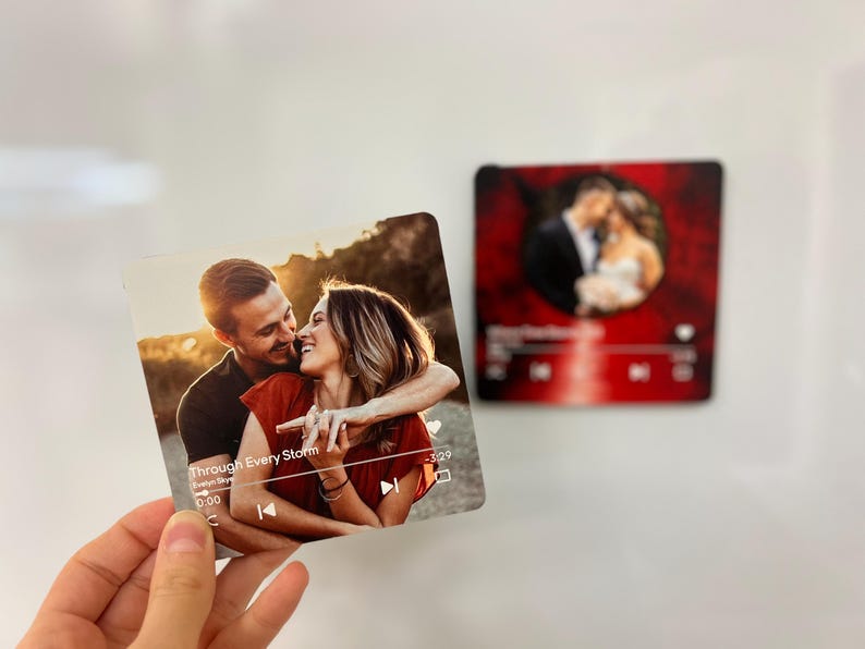 May include: A square photo print featuring a couple embracing, with the text "Through Every Storm" and a music player interface. A second print shows a couple in formal wear. The prints are likely personalized gifts.