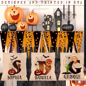 May include: Three Halloween trick-or-treat bags with personalised names: Sophia, Daniela, and George. Each bag features a black and orange polka dot design with a spiderweb, a spider, and a pumpkin. The bags are hanging from a black and orange garland with black polka dots.