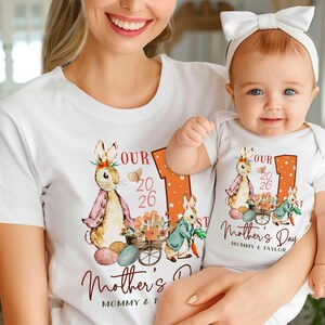 Puede incluir: Camisetas y body blancos con un dise&ntilde;o de conejito y flores para el D&iacute;a de la Madre. Las camisetas tienen el texto "OUR 2026 Mother's Day" y "MOMMY & TAYLOR". El beb&eacute; lleva un lazo blanco.