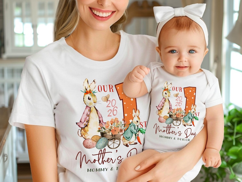 Puede incluir: Camisetas y body blancos con un dise&ntilde;o de conejito y flores para el D&iacute;a de la Madre. Las camisetas tienen el texto "OUR 2026 Mother's Day" y "MOMMY & TAYLOR". El beb&eacute; lleva un lazo blanco.