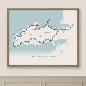 May include: A framed map print of The Dingle Way in Ireland. The map features a dark blue line tracing the trail's route against a light blue and cream background. The text "THE DINGLE WAY - IRELAND-" is at the bottom.