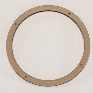 May include: A circular wooden frame with a light brown color. The frame has a consistent width and features four evenly spaced holes. The object is designed with a smooth, rounded edge.
