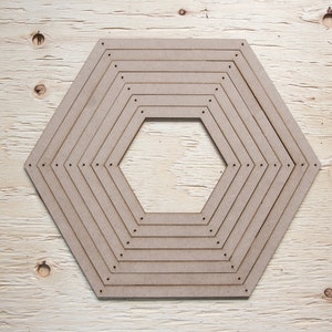 May include: A collection of light brown, hexagonal wooden frames, nested within each other. Each frame has small holes along the edges. The frames are arranged in a decreasing size pattern, with the smallest hexagon in the centre.