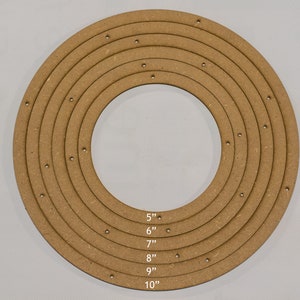 May include: A set of concentric wooden circles, ranging from 5" to 10" in diameter, with evenly spaced holes. The circles are made of light brown wood and are arranged in a nested pattern. The sizes are labeled with white text.