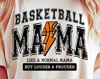 May include: Cream-colored t-shirt with the text "BASKETBALL MAMA" in black, outlined in white. An orange basketball and lightning bolt graphic is in the center. Below it reads "LIKE A NORMAL MAMA BUT LOUDER & PROUDER."