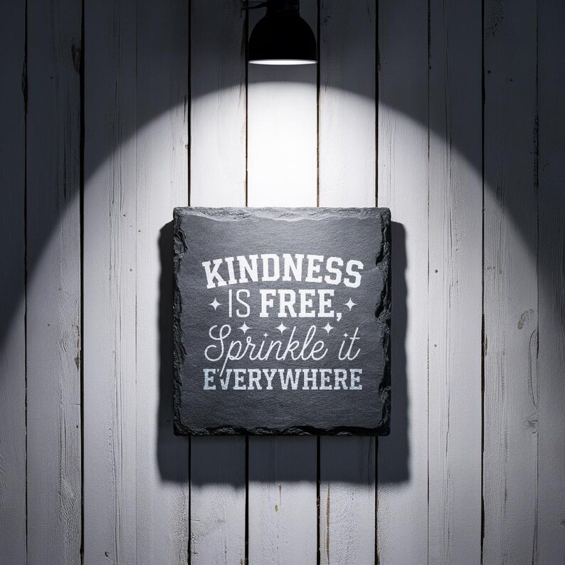 May include: Black slate sign with white text that reads "KINDNESS IS FREE, Sprinkle it EVERYWHERE".
