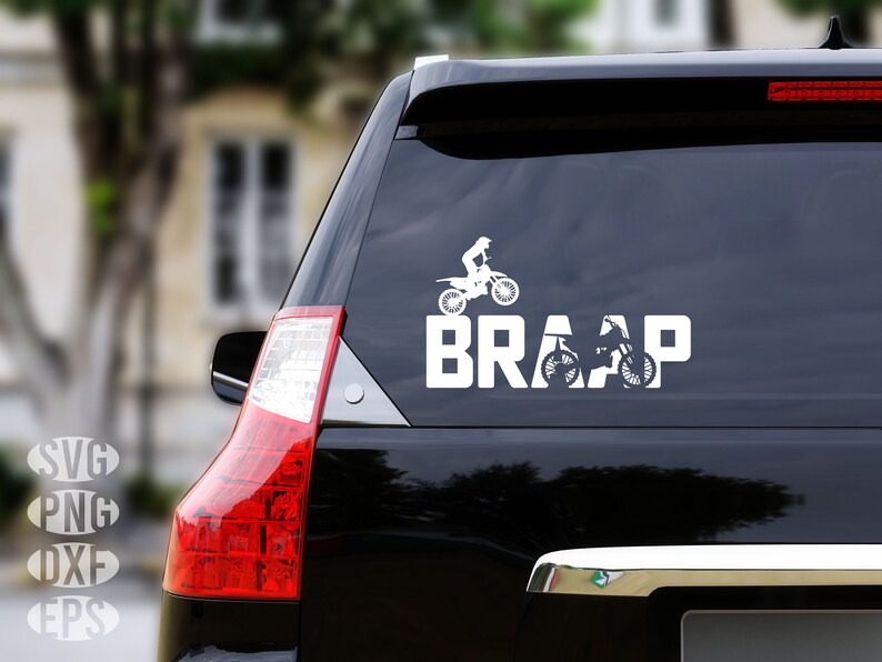 Op de afbeelding: Een witte vinyl sticker met een silhouet van een persoon die een crossmotor rijdt en het woord "BRAAP" op een zwarte auto.