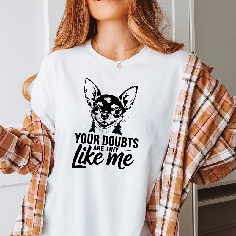 Puede incluir: Camiseta blanca con una ilustraci&oacute;n en blanco y negro de un chihuahua y el texto "Tus dudas son peque&ntilde;as como yo".