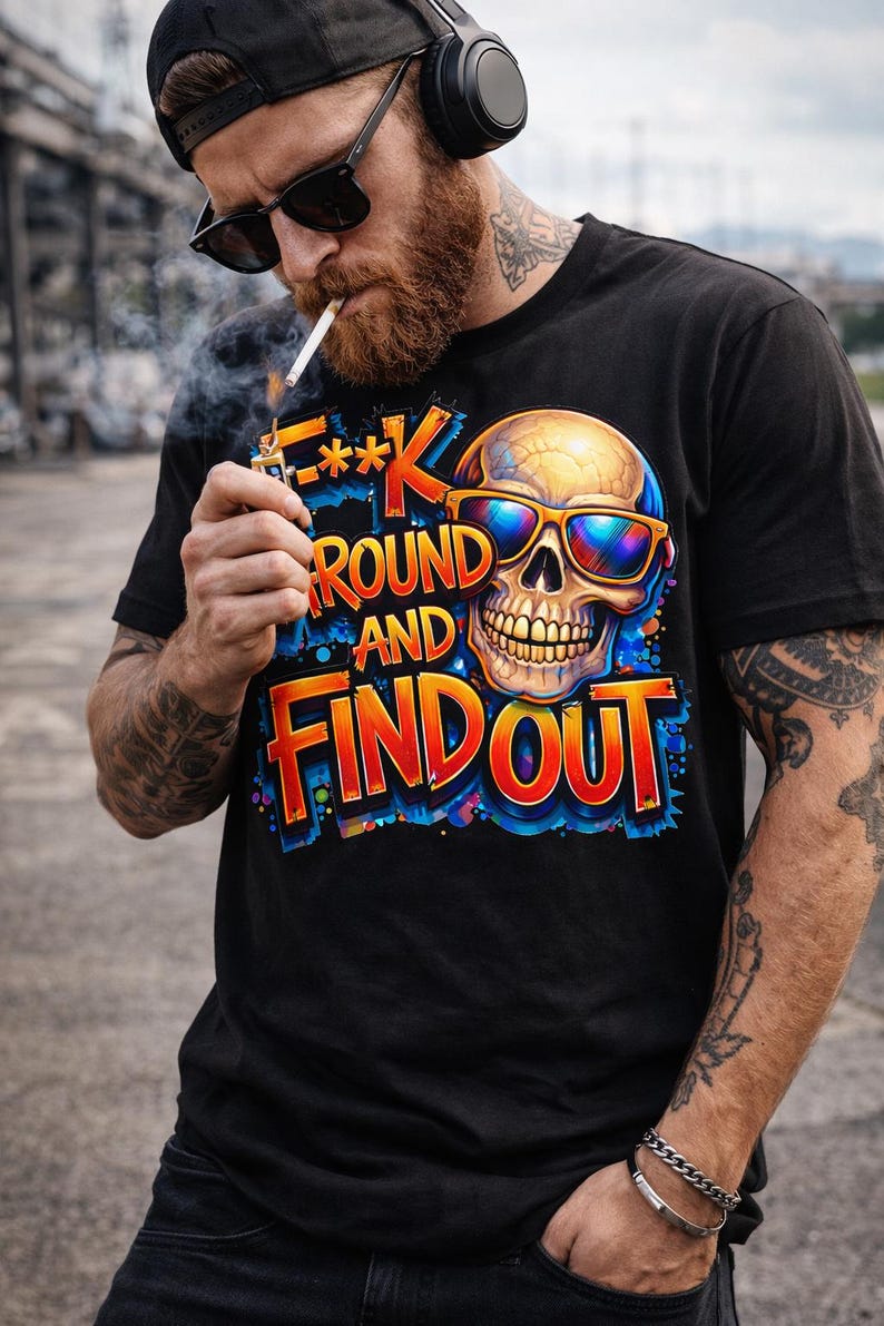 May include: Black t-shirt with a colorful graphic of a skull wearing sunglasses and the text "F**k Around and Find Out". The design features orange, blue, and yellow hues. The shirt is short-sleeved.