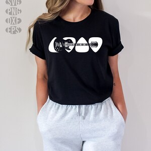 May include: A black t-shirt with a white graphic of a guitar inside of three guitar picks.