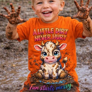 May include: An orange t-shirt with the text "A Little Dirt Never Hurt" and a cartoon cow graphic. The shirt is worn by a child covered in mud, with the words "Fun starts messy" on the shorts.