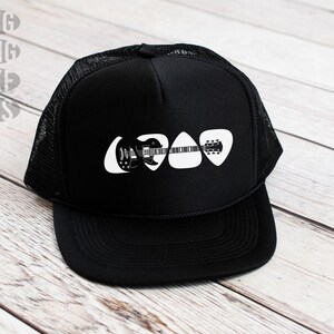 May include: Black trucker hat with a white graphic of a guitar made of guitar picks.