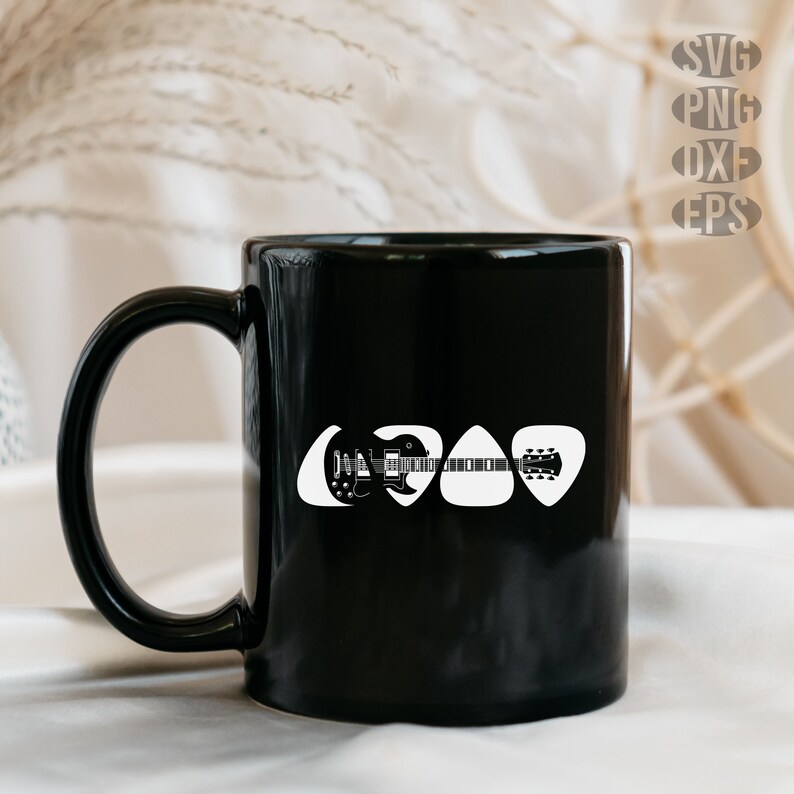 May include: Black coffee mug with a white silhouette of a guitar and three guitar picks. The mug is on a white surface.