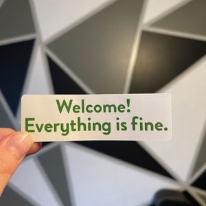 May include: A white sticker with green text that reads "Welcome! Everything is fine."