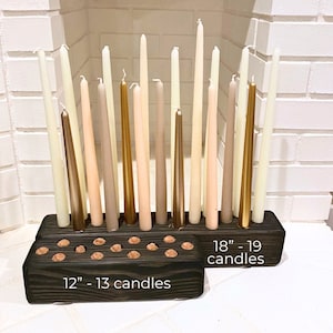 Op de afbeelding: Een houten kaarsenhouder met 19 gaten voor kaarsen. De houder is donkerbruin en heeft de tekst "18" - 19 kaarsen" en "12" - 13 kaarsen" erop geschreven.