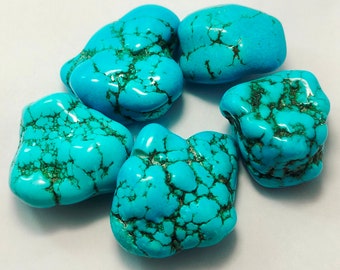 May include: Six polished turquoise stones with a vibrant blue-green hue and dark brown veining. The stones are irregularly shaped and arranged in a circular pattern, showcasing their natural beauty.