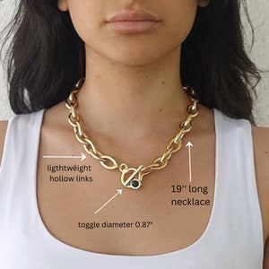 May include: Gold chain necklace with lightweight hollow links and a toggle clasp. The necklace is 19 inches long and the toggle is 0.87 inches in diameter.