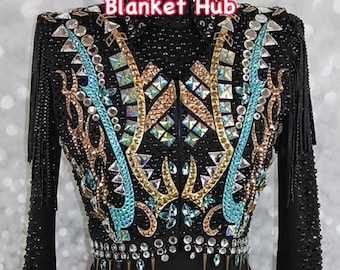 Könnte beinhalten: Schwarze Showjacke mit türkisfarbenen, goldenen und silbernen Verzierungen. Die Jacke hat einen Reißverschluss und lange Ärmel mit Fransen. Der Text "Blanket Hub" befindet sich auf der Vorderseite der Jacke.