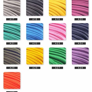 May include: A collection of thirteen square swatches displaying braided cord in various colors, labeled A17 through A29. The colors include gray, black, yellow, magenta, teal, blue, pink, dark blue, olive, gold, green, purple, and bright orange.