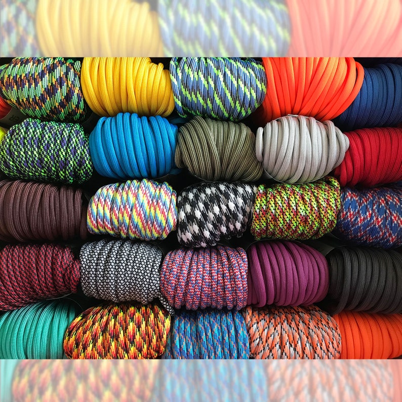 May include: A collection of coiled paracord bundles arranged in a grid. The cords feature a variety of solid colors including yellow, blue, orange, red, brown, purple, and black, alongside multi-colored patterns like camouflage, stripes, and checks.