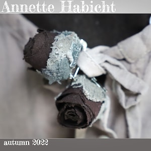 TWO ROSES, each with a small safety pin, with frayed leaves, hand-dyed antique linen, mocha