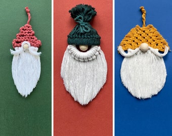 Puede incluir: Tres adornos de gnomos de macramé con barbas blancas, narices de madera y sombreros coloridos. Uno tiene un sombrero rojo, otro un sombrero verde y el tercero un sombrero amarillo. El texto "3-en-1 macrame patterns" está en la parte inferior.