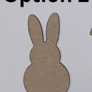 May include: A brown wooden cutout of a bunny rabbit with long ears. The cutout is shaped like a traditional Easter bunny.
