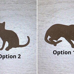May include: Two brown cat silhouettes on a light wood grain surface. One cat is sitting, the other is in a running pose. Text below each cat reads "Option 2" and "Option 1".