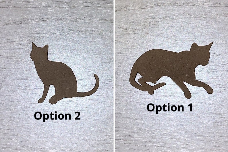 May include: Two brown cat silhouettes on a light wood grain surface. One cat is sitting, the other is in a running pose. Text below each cat reads "Option 2" and "Option 1".
