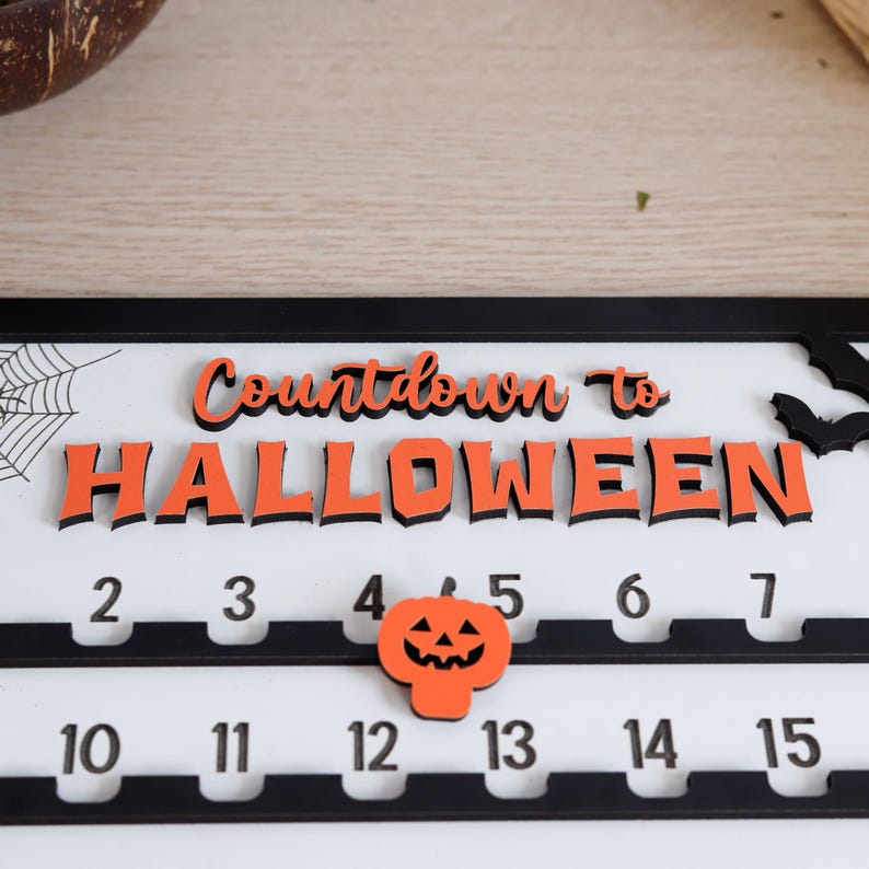 May include: A Halloween countdown calendar with the words "Countdown to Halloween" in orange and black. The calendar has numbers 2-7 and 10-15, with a pumpkin icon. A spiderweb and bats are also visible.