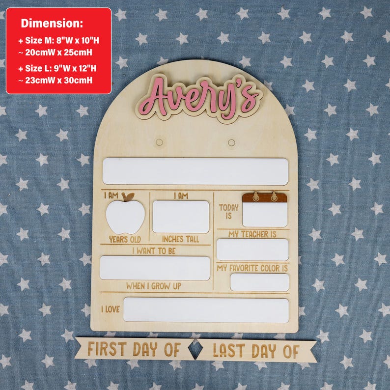 May include: Wooden school board with the name "Avery's" in pink. The board has spaces for "Years Old," "Inches Tall," "My Teacher Is," and "My Favorite Color Is." Includes a banner that reads "First Day Of" and "Last Day Of."