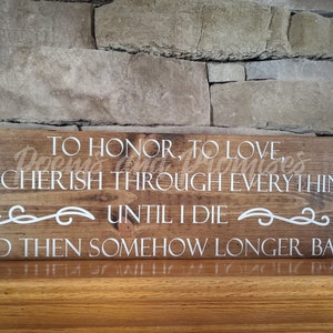 May include: A wooden sign with the text "TO HONOR, TO LOVE, TO CHERISH THROUGH EVERYTHING UNTIL I DIE AND THEN SOMEHOW LONGER BABE" in white lettering.