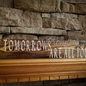 May include: A wooden sign with the text "My Tomorrows Are All Yours" in white lettering on a dark brown background.