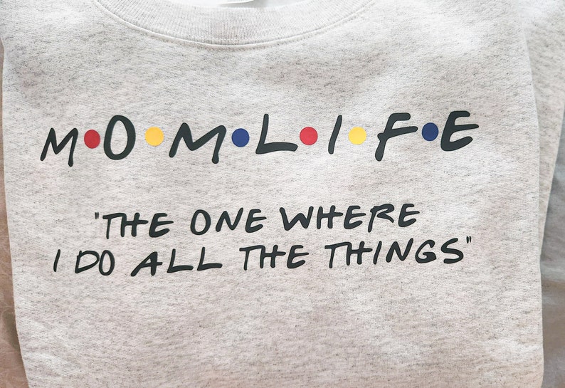 May include: Gray sweatshirt with the text "M.O.M.L.I.F.E." in black with colorful dots, and the text "The One Where I Do All The Things" in black.