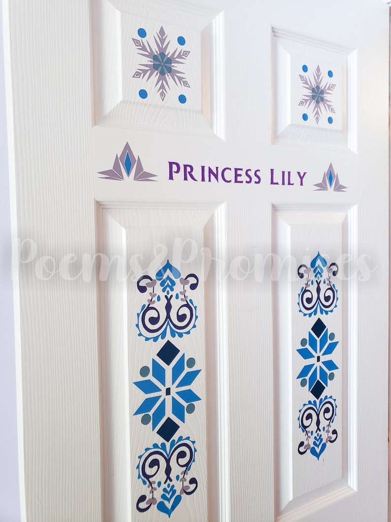 K&ouml;nnte beinhalten: Wei&szlig;e T&uuml;r mit einer lila Aufschrift "Princess Lily" mit einem Schneeflockenmuster auf jedem Feld. Die T&uuml;r ist mit blauen und grauen Schneeflockenmustern verziert.