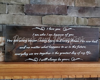 May include: A dark brown wooden sign with white text that reads "I love you. I am who I am because of you. You are every reason, every hope, and every dream I've ever had, and no matter what happens to us in the future, everyday we are together is the greatest day of my life. I will always be yours."