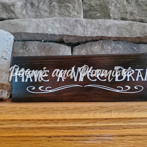 May include: A dark brown wooden sign with white lettering that reads "Have a Wonderful Dream". The sign has a decorative scroll design.