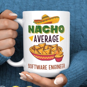 May include: White ceramic mug featuring the humorous slogan "Nacho Average Software Engineer" with a cartoon sombrero and a bowl of nachos.