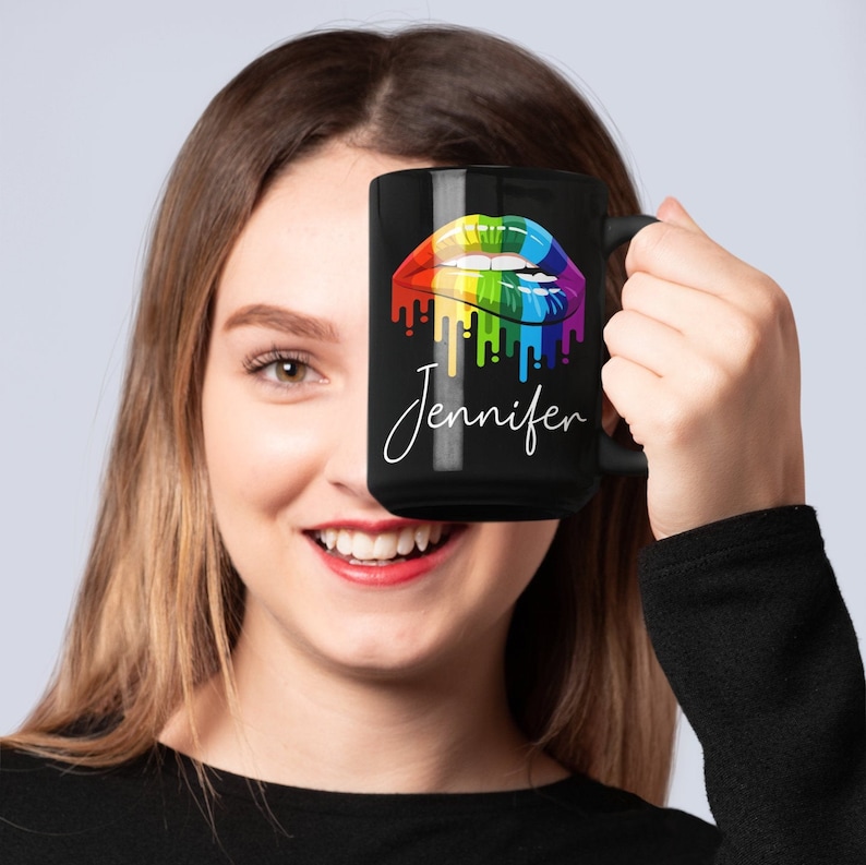May include: Black coffee mug with a rainbow dripping lips design and the name "Jennifer" in white script.
