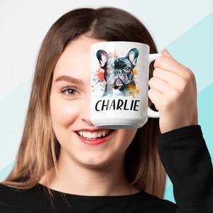 Pode incluir: Caneca de cer&acirc;mica branca com uma ilustra&ccedil;&atilde;o em aquarela de um Bulldogue Franc&ecirc;s. O c&atilde;o &eacute; preto e tem um respingo de tinta colorida atr&aacute;s. A caneca tem o nome "CHARLIE" impresso nela.