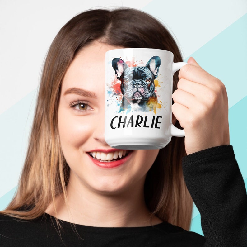 Pode incluir: Caneca de cer&acirc;mica branca com uma ilustra&ccedil;&atilde;o em aquarela de um Bulldogue Franc&ecirc;s. O c&atilde;o &eacute; preto e tem um respingo de tinta colorida atr&aacute;s. A caneca tem o nome "CHARLIE" impresso nela.