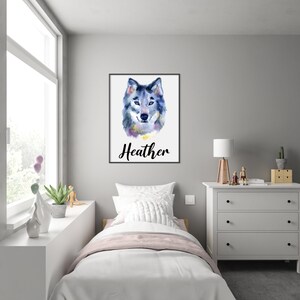 May include: Watercolor painting of a wolf's head in shades of blue, gray, and purple, set against a white background. The name "Heather" is written in cursive below the image, framed in a black border. The artwork is displayed in a bedroom.