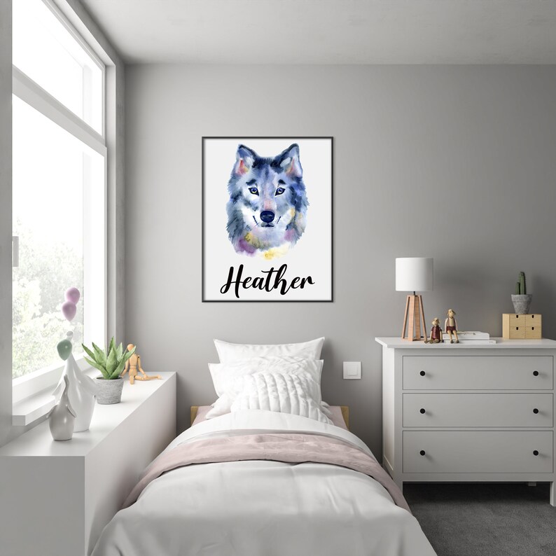 May include: Watercolor painting of a wolf's head in shades of blue, gray, and purple, set against a white background. The name "Heather" is written in cursive below the image, framed in a black border. The artwork is displayed in a bedroom.