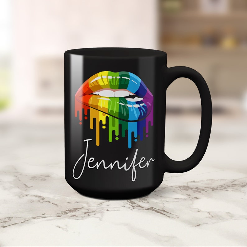 May include: Black coffee mug with a rainbow dripping lips design and the name Jennifer in white script.