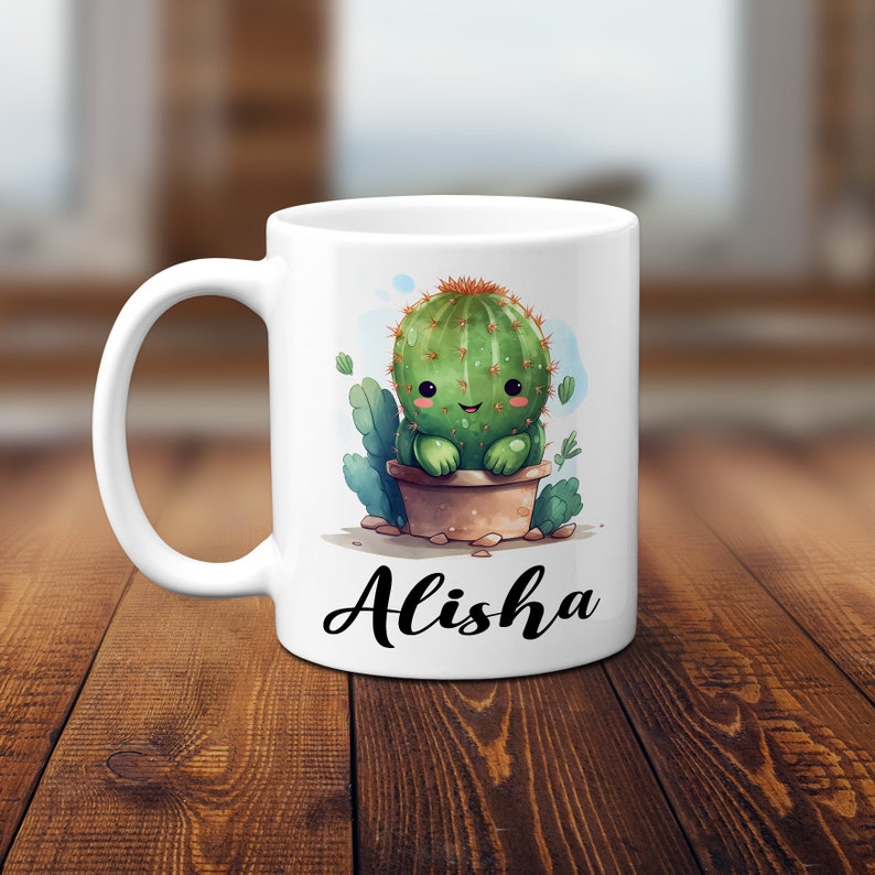 May include: White ceramic mug with a cartoon cactus illustration and the name "Alisha" printed on the front.