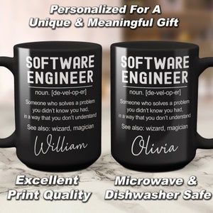 K&ouml;nnte beinhalten: Zwei schwarze Kaffeetassen mit wei&szlig;em Text. Die Tassen zeigen eine Definition eines Softwareentwicklers mit den Worten "Software Engineer" und "noun. [de-vel-op-er]" darauf gedruckt. Die Tassen sind mit den Namen "William" und "Olivia" personalisiert. Der Text am Boden der Tassen lautet "Excellent Print Quality" und "Microwave & Dishwasher Safe".