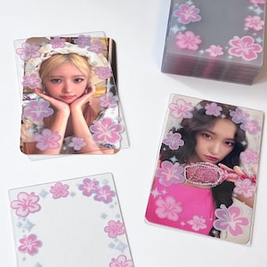 May include: Two clear plastic photo card holders with pink hibiscus flower designs. The photo cards feature images of two women. One photo card has a woman with blonde hair and a white hat, the other photo card has a woman with dark hair wearing a pink top.