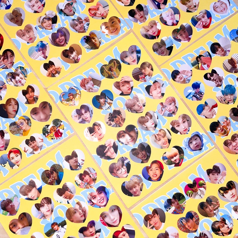 Op de afbeelding: Een collage van gele hartvormige stickers met foto's van een jongensband. De stickers zijn in een rasterpatroon op een wit oppervlak gerangschikt. De bandleden dragen allemaal verschillende outfits en kapsels. De stickers zijn allemaal scherp en de kleuren zijn levendig.